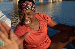 Runner smiling with hand raised.