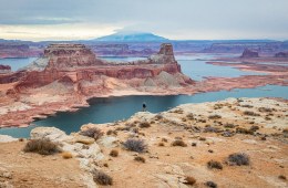 The photo is of the Arizona desert with the silhouette of a man (Mylo Fowler) standing at the edge of the landscape looking out at the river.