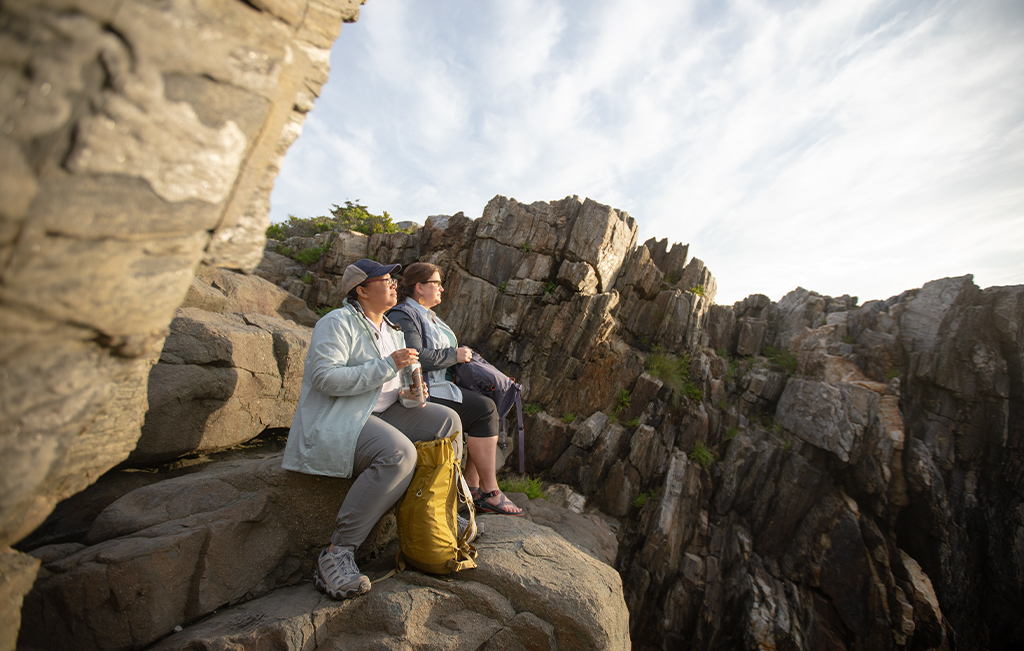 Two hikers taking a break on a rock ledge