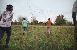 Kids running through tall grass.