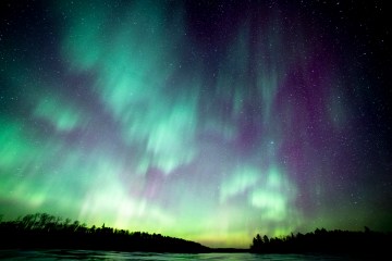 The green and purple glow of the Northern Lights over the Boundary Waters in northern Minnesota
