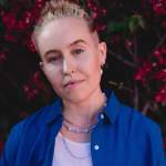 Portrait of Fiona Lowenstein, wearing a royal blue shirt over a white tank top.