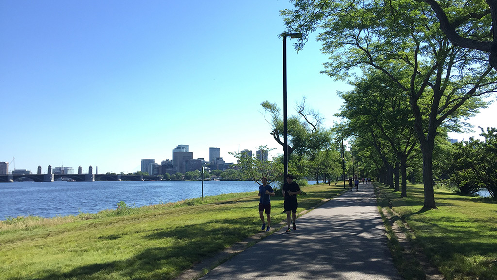 Two people run along a riverfront trail in Boston. 