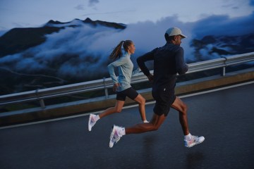 A man and a woman run on a foggy stretch of road in the On Cloudprime, featuring CleanCloud technology.