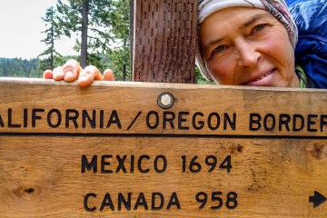 Thru hiker Jasmine Star stops at a trail marker on the PCT.