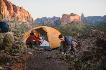 Two people setup camp.