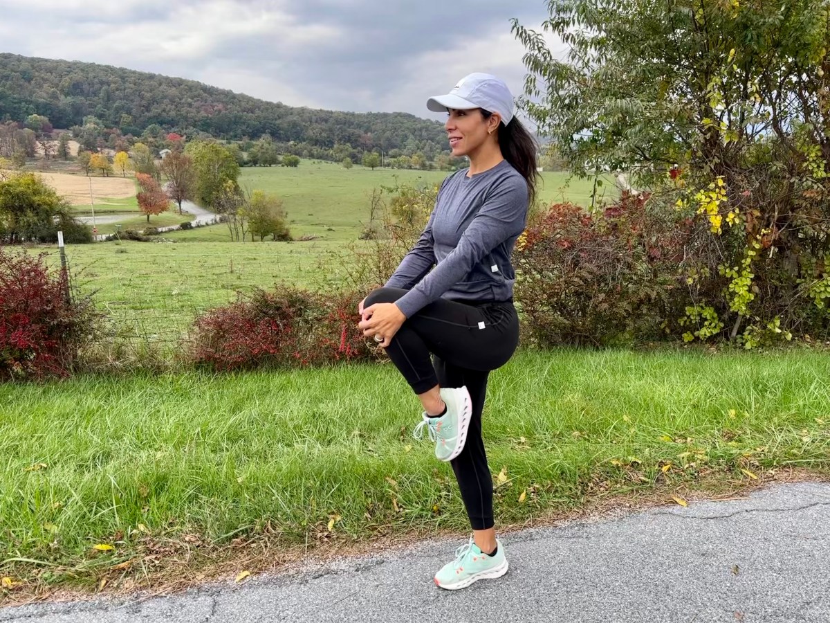 Photo of woman in running gear stretching.