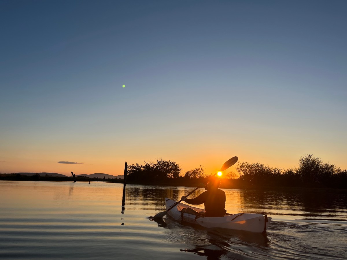 The author paddles towards the sunset in his Oru Kayak Lake Kayak