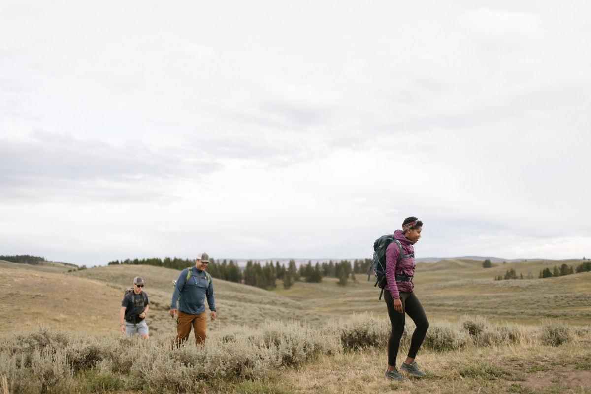 Three hikers explore a solitary plain.