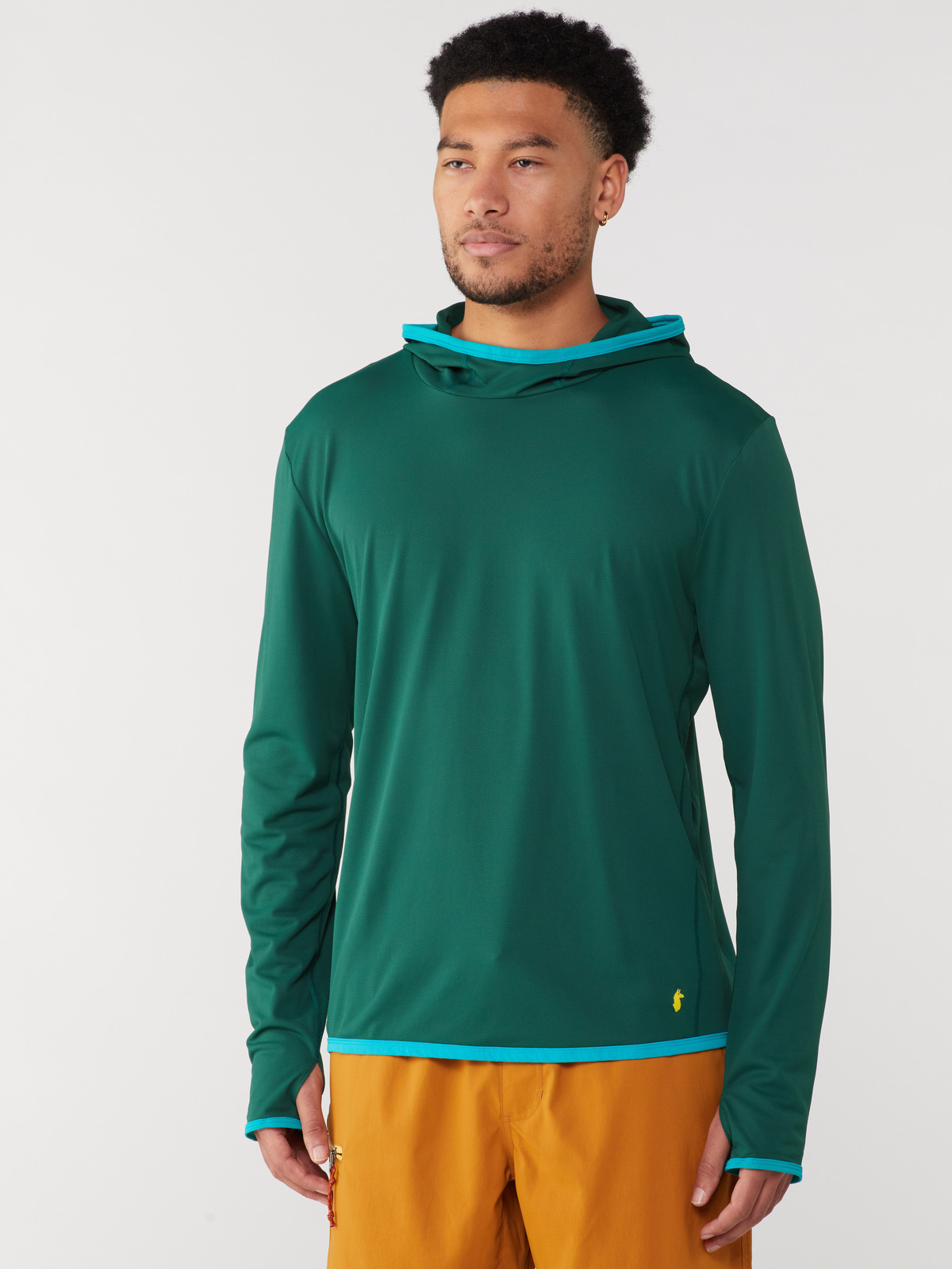 A person wearing a green Cotopaxi sun hoodie with blue trim.
