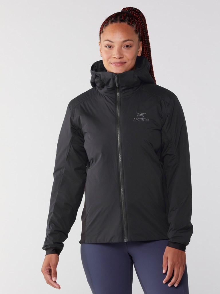 A person with long black and dyed-red braids wearing a black Arc'teryx hoodie.