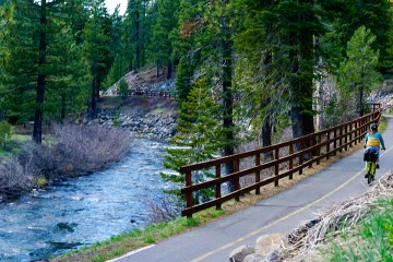 A person bikes along a scenic bike and pedestrian path in North Lake Tahoe.