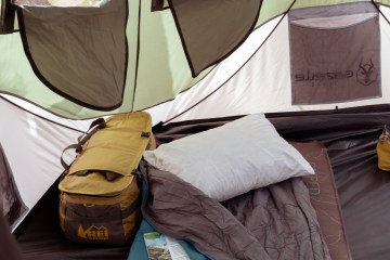 A sleeping bag and pillow inside a tent at camp.