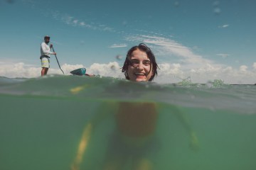 A swimmer is shown halfway submerged underwater, with their head above the surface.