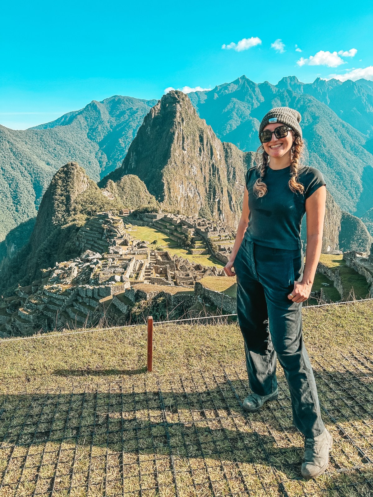 Photo of a female hiker standing in front of a view from the Inca Trail in Peru