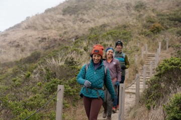 Three people hiking down a trail