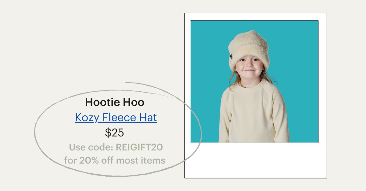 A smiling child wears a cozy fleece hat. Hootie Hoo's Kozy Fleece Hat, $25. Use code: REIGIFT20 for 20% off most items.