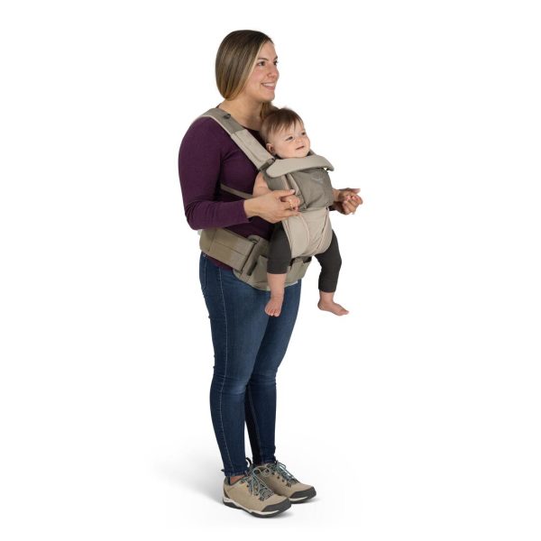 A person wears the Osprey Soft Child Carrier LT in the front position with a child front-facing.