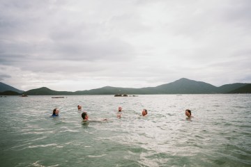 Photo of six people swimming in a body of water.