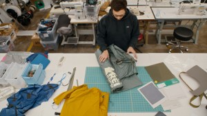 A designer rolls out a tent on a table