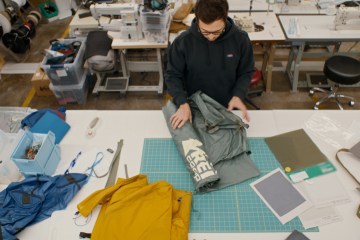 A designer rolls out a tent on a table
